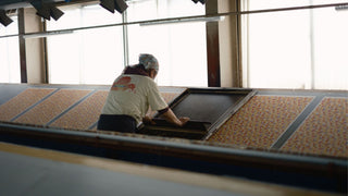 Person working on a manual printing some paper at the Shogado factory in  Kyoto - Shibuya Stationery Store