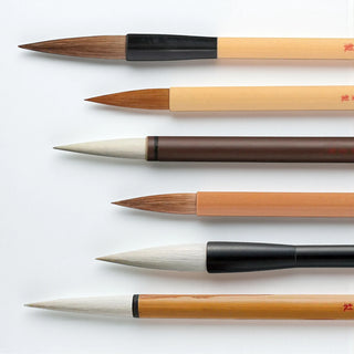 Bundle of six Kuretake brand Japanese made calligraphy brushes up close with white and brown hair shown in a horizontal row on a white background - Shibuya Stationery Store