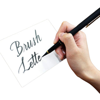 Hand writing 'Brush Letter' with a Kuretake number 15 black lacquered brush pen on white paper - Shibuya Stationery Store