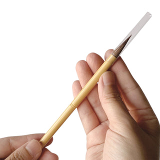 Hand holding a small calligraphy brush from Kuretake on a white background - Shibuya Stationery Store