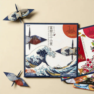 Origami paper pack featuring Hokusai’s The Great Wave off Kanagawa from the Thirty-Six Views of Mount Fuji series, with folded crane samples displayed beside the origami pack.