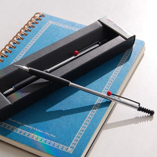 The Tombow Zoom 707 de Luxe Ballpoint Pen 0.7mm is placed on top of the notebook in the package - Shibuya Stationery