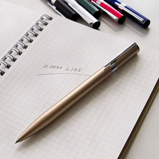 Zoom L105 Ballpoint Pen 0.5mm Gold placed on notebook labeled L105 – Shibuya Stationery