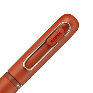 Detailed view of the rear barrel color selectors on the Uni-ball One 3 multi pen in Brick Red for switching between ink colors.