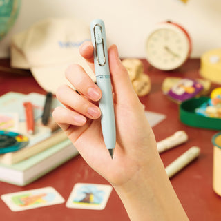 Hand holding the Uni-ball One 3 3-Color Gel Ink Multi Pen in Shirt Blue to demonstrate its size, proportions, and grip.