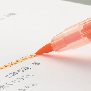 Orange ZIG Brush High-Lite Quick C+ Highlighter being used on a document with Japanese text - Shibuya Stationery Store