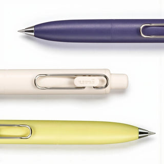 Three Mitsubishi Pencil brand uni ball one P 0.5mm tip size black ink gel pens close up in a bundle in purple, yogurt, and yellow on a white background - Shibuya Stationery Store